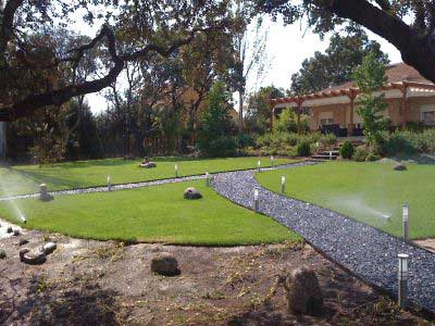 jardín con sendero iluminado y regadío